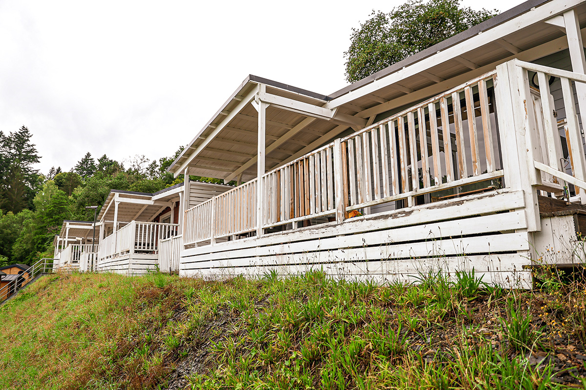 Les chalets Emotion vus de l'extérieur, avec leur terrasse blanche à flanc de coteau au Camping Kaul