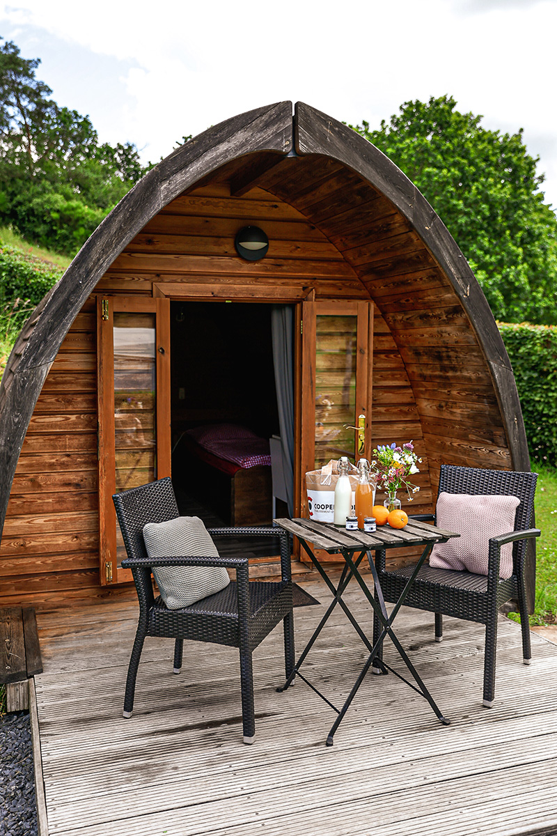 Wooden pod with open door and a laid table on the terrace