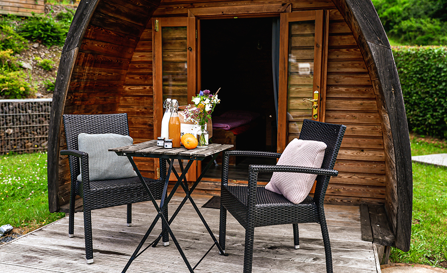 Camping pod from outside with terrace, table and chairs at Camping Kaul
