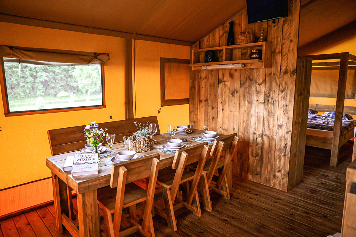 Laangen Holzdësch am Safari-Zelt mat Bléck no baussen um Camping Kaul